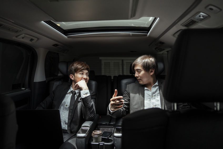 Two business men in a limo, talking